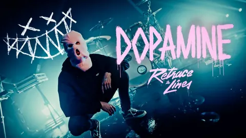 Dopamine video thumbnail: a figure in a pink balaclava crouching on stage, Dopamine sprayed in pink